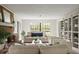 Sunlit living room with brick fireplace, comfortable seating, and built-in shelving at 12603 Corral Rd, Tampa, FL 33626