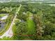Aerial image defining property lines of land surrounded by mature trees and a pond at 12603 Corral Rd, Tampa, FL 33626
