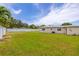 A large backyard with green grass and a tall white fence on a sunny day at 12877 Palm Dr, Largo, FL 33774