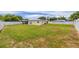 Large, grassy backyard enclosed by a white fence under a bright sky at 12877 Palm Dr, Largo, FL 33774