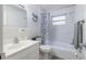 Clean bathroom with white tile, a shower-tub combo, and a vanity sink at 12877 Palm Dr, Largo, FL 33774