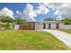 Charming one-story home with stone accents, a well-maintained lawn, and a cracked driveway at 12877 Palm Dr, Largo, FL 33774