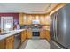 This kitchen has stainless steel appliances, light wood cabinets, and a tile backsplash at 12877 Palm Dr, Largo, FL 33774