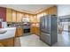 Bright kitchen features light wood cabinets, stainless steel appliances, and tile flooring at 12877 Palm Dr, Largo, FL 33774