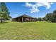 Beautiful backyard with a covered patio, lush lawn, and mature landscaping at 13102 Done Groven Dr, Dover, FL 33527