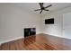 Well-lit bedroom with neutral walls, wood floors, a ceiling fan, and tv for modern comfort at 13102 Done Groven Dr, Dover, FL 33527