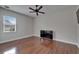 Cozy bedroom featuring a ceiling fan, a window for natural light, and sleek wood flooring at 13102 Done Groven Dr, Dover, FL 33527
