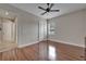 Bright bedroom featuring wood floors, a ceiling fan, and a window for natural light and a hall access at 13102 Done Groven Dr, Dover, FL 33527