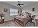 Cozy bedroom featuring a wooden frame bed, ceiling fan, and natural light from the windows at 13102 Done Groven Dr, Dover, FL 33527