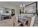 Formal dining area featuring a chandelier, mirror, and a rustic wooden table set for a meal at 13102 Done Groven Dr, Dover, FL 33527