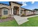 Beautiful home entrance with large windows, prominent columns, and a well-manicured lawn at 13102 Done Groven Dr, Dover, FL 33527