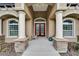 Inviting home entrance with elegant columns, stylish double doors, and attractive landscaping at 13102 Done Groven Dr, Dover, FL 33527