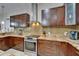 Beautiful kitchen boasts granite counters, custom cabinets, stainless appliances, and tiled backsplash at 13102 Done Groven Dr, Dover, FL 33527