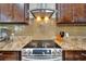 A modern kitchen featuring granite countertops, stainless steel appliances, and a stylish range hood at 13102 Done Groven Dr, Dover, FL 33527