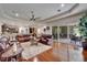 Spacious living room with hardwood floors, a large sectional sofa, and sliding glass doors to outdoor patio at 13102 Done Groven Dr, Dover, FL 33527
