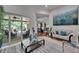 Comfortable living room leading to outdoor patio, featuring sofas, artwork, and natural light at 13102 Done Groven Dr, Dover, FL 33527