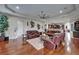 Elegant living room with hardwood floors, leather seating, modern art, and an open floor plan to kitchen at 13102 Done Groven Dr, Dover, FL 33527