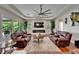 Spacious living room with a fireplace, large screen TV, hardwood floors, and abundant natural light at 13102 Done Groven Dr, Dover, FL 33527