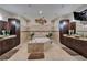 Luxurious main bathroom with a soaking tub, dual vanities, decorative wall art, and travertine floors at 13102 Done Groven Dr, Dover, FL 33527