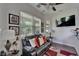 Sitting area features hardwood floors, a ceiling fan, a black leather sofa, and backyard views at 13102 Done Groven Dr, Dover, FL 33527
