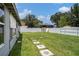 Spacious backyard featuring a white fence, stepping stones, and ample green space for outdoor activities at 15906 Country Farm Pl, Tampa, FL 33624
