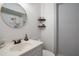 Bathroom featuring a round mirror, floating shelves, a white vanity and a walk-in shower at 15906 Country Farm Pl, Tampa, FL 33624
