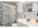 Bathroom featuring patterned shower curtain, modern vanity, and neutral decor at 15906 Country Farm Pl, Tampa, FL 33624