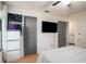 Bedroom featuring wood laminate floors, ceiling fan, television, and storage at 15906 Country Farm Pl, Tampa, FL 33624