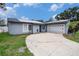 Attractive single-story home with a spacious driveway, solar panels, and a two-car garage at 15906 Country Farm Pl, Tampa, FL 33624