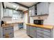 Bright kitchen features updated gray cabinetry with gold hardware and wood countertops at 15906 Country Farm Pl, Tampa, FL 33624