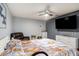 Main bedroom with ceiling fan, television, and decorative monogrammed wall decor at 15906 Country Farm Pl, Tampa, FL 33624