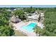 Community pool with ample seating, surrounded by lush landscaping, providing a resort-style amenity for residents at 1600 Amberlea N Dr, Dunedin, FL 34698