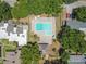Aerial view of the community pool, surrounded by trees and homes, providing a refreshing amenity for residents at 1600 Amberlea N Dr, Dunedin, FL 34698