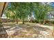 A large backyard with a patio area is shaded by mature trees and has a wood fence at 1600 Amberlea N Dr, Dunedin, FL 34698
