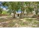 This backyard features a patio area and is partially shaded by large trees at 1600 Amberlea N Dr, Dunedin, FL 34698