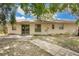 View of the rear exterior of the home with access to a patio area at 1600 Amberlea N Dr, Dunedin, FL 34698