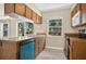 Functional kitchen with wood cabinets, tile floors, and modern appliances at 1600 Amberlea N Dr, Dunedin, FL 34698