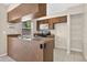 Functional kitchen with wood cabinets, tile floors, and a peninsula counter at 1600 Amberlea N Dr, Dunedin, FL 34698