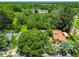 An aerial view of a property, highlighting its proximity to wooded areas and a pond, surrounded by lush greenery at 16138 Manorwood Cir, Tampa, FL 33624
