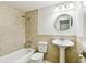 Well-lit bathroom with tiled shower, tub, pedestal sink, and modern fixtures at 16138 Manorwood Cir, Tampa, FL 33624