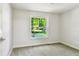 Bright, carpeted bedroom with a large window letting in natural light and a view of the outdoors at 16138 Manorwood Cir, Tampa, FL 33624