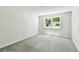 Bright, carpeted bedroom with a large window letting in natural light and a view of the outdoors at 16138 Manorwood Cir, Tampa, FL 33624