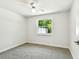 The bedroom has neutral carpet, a window, and a ceiling fan at 16138 Manorwood Cir, Tampa, FL 33624