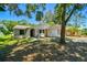 Charming single-story home with a well-maintained lawn and mature trees providing shade in a suburban neighborhood at 16138 Manorwood Cir, Tampa, FL 33624