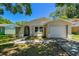 Charming single-Gathering home featuring a one-car garage and an inviting, arched entryway in a tranquil, tree-lined neighborhood at 16138 Manorwood Cir, Tampa, FL 33624