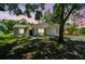 A charming single-story home with a well-maintained lawn and mature trees in a suburban neighborhood at sunset at 16138 Manorwood Cir, Tampa, FL 33624