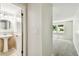 Hallway that opens to bedroom and a powder room with pedestal sink and modern fixtures at 16138 Manorwood Cir, Tampa, FL 33624