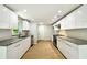 Modern kitchen boasts sleek white cabinets, granite countertops, stainless steel appliances, and wood-look flooring at 16138 Manorwood Cir, Tampa, FL 33624