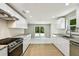 Bright, open kitchen featuring modern cabinetry, stainless steel appliances, and sliding glass doors to the outdoor patio at 16138 Manorwood Cir, Tampa, FL 33624