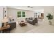 Staged living room with tile floors, gray sofa, and views into the backyard and dining area at 16138 Manorwood Cir, Tampa, FL 33624
